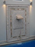 custom made modern wall water features, Pool plaque travertine inset with tumbled marble tile relief, rivets and water pourer, lava stone off white finish