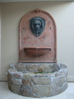 Aged terracotta Tuscan style wall plaque and bowl with bronzed lions head and forged bronzed bowl banding and rivets